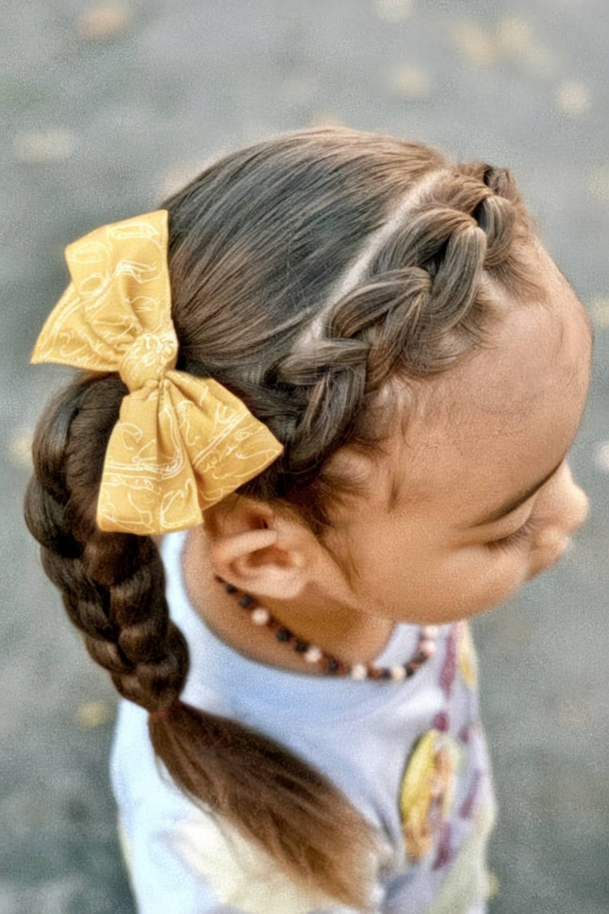 Braided toddler hairstyle with curly low ponytails