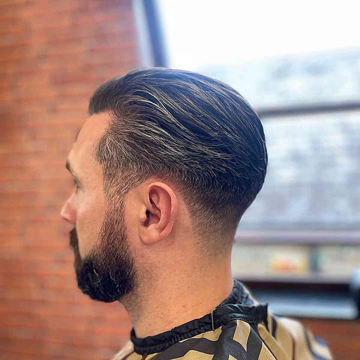 Sleek and Straight Low Taper Fade Hairstyle for Men's Full Beard