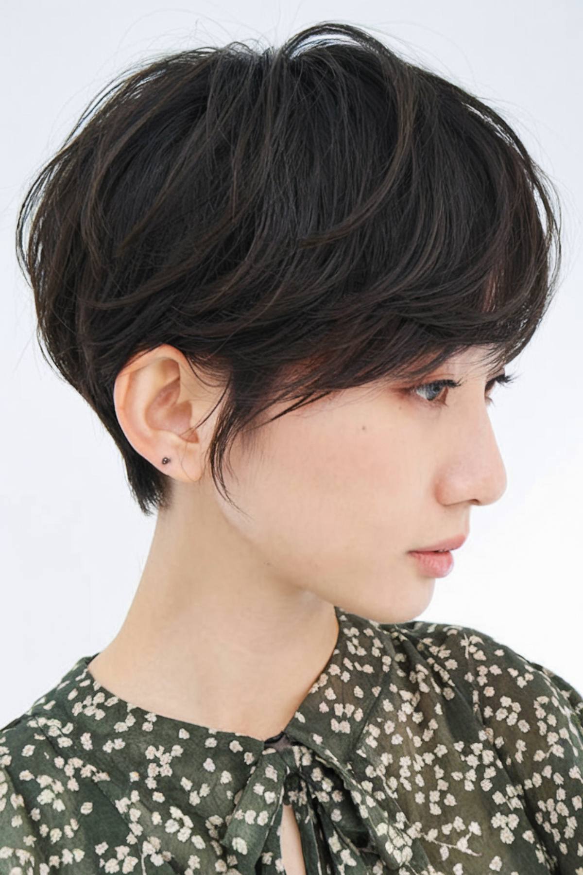 Asian-style short layered haircut with tapered layers and volume at the crown