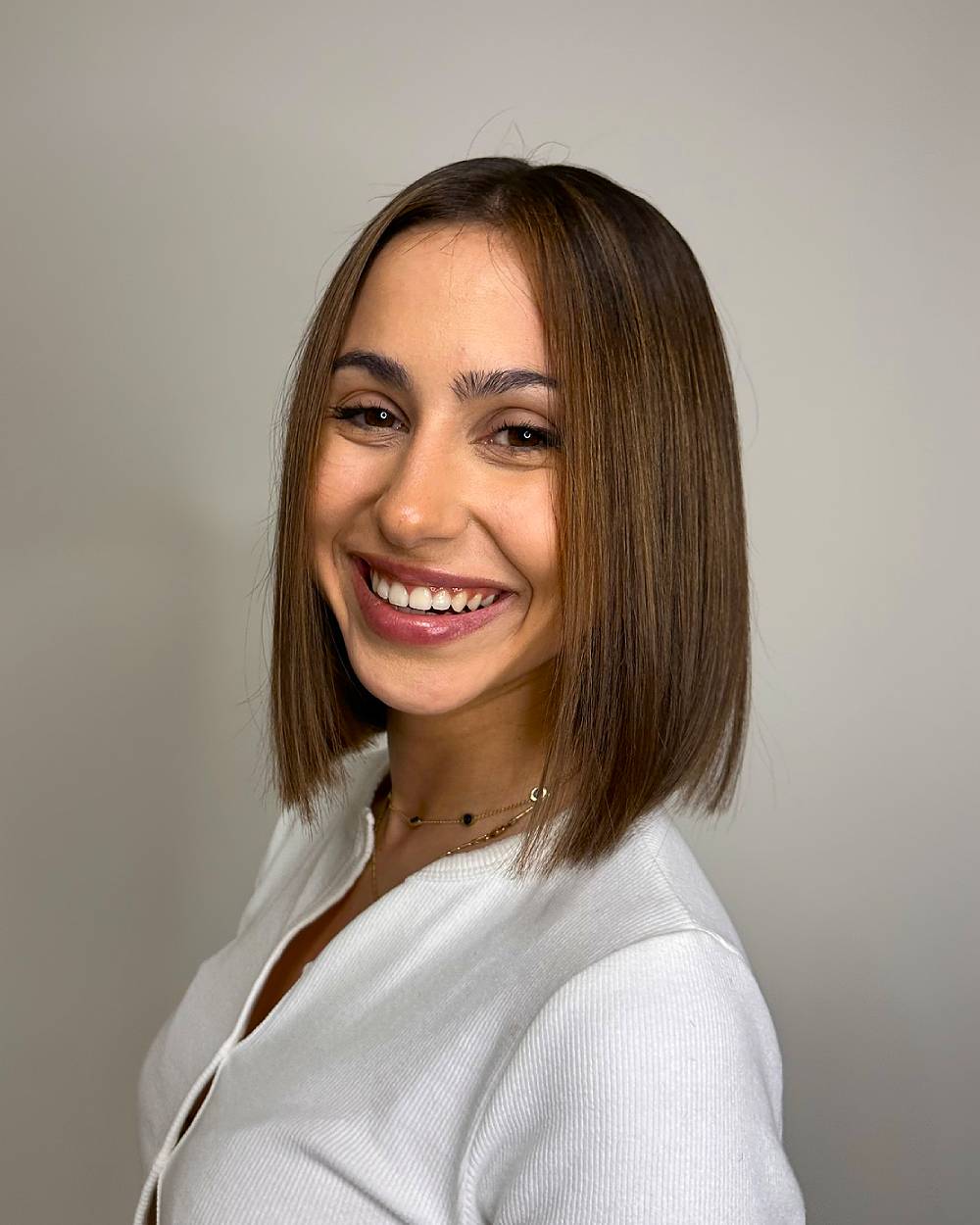 Sleek blunt bob with middle part, a sharp and polished chin-length bob for straight fine to medium hair