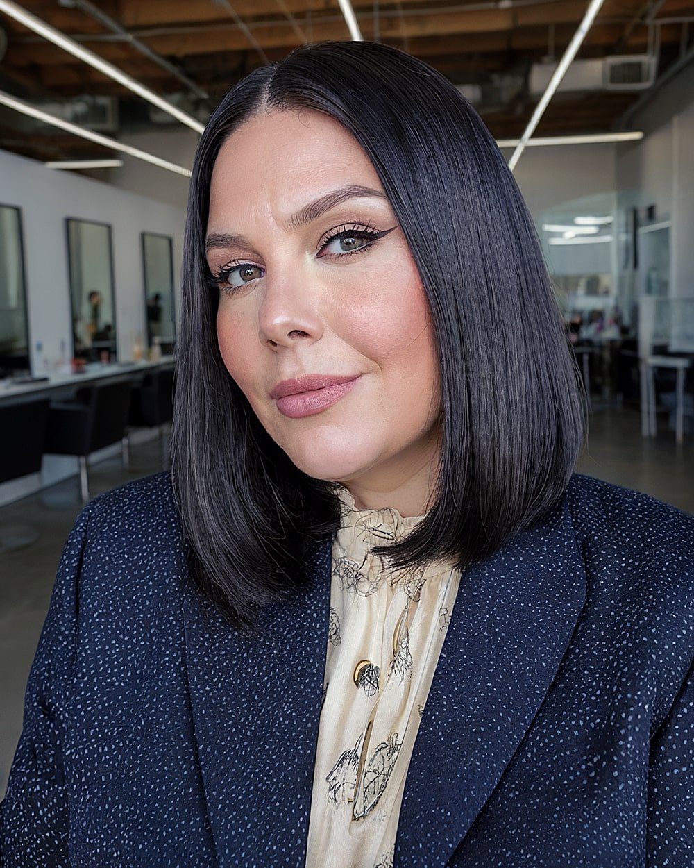Sleek blunt shoulder-length bob with middle part for women over 40 with round face shapes