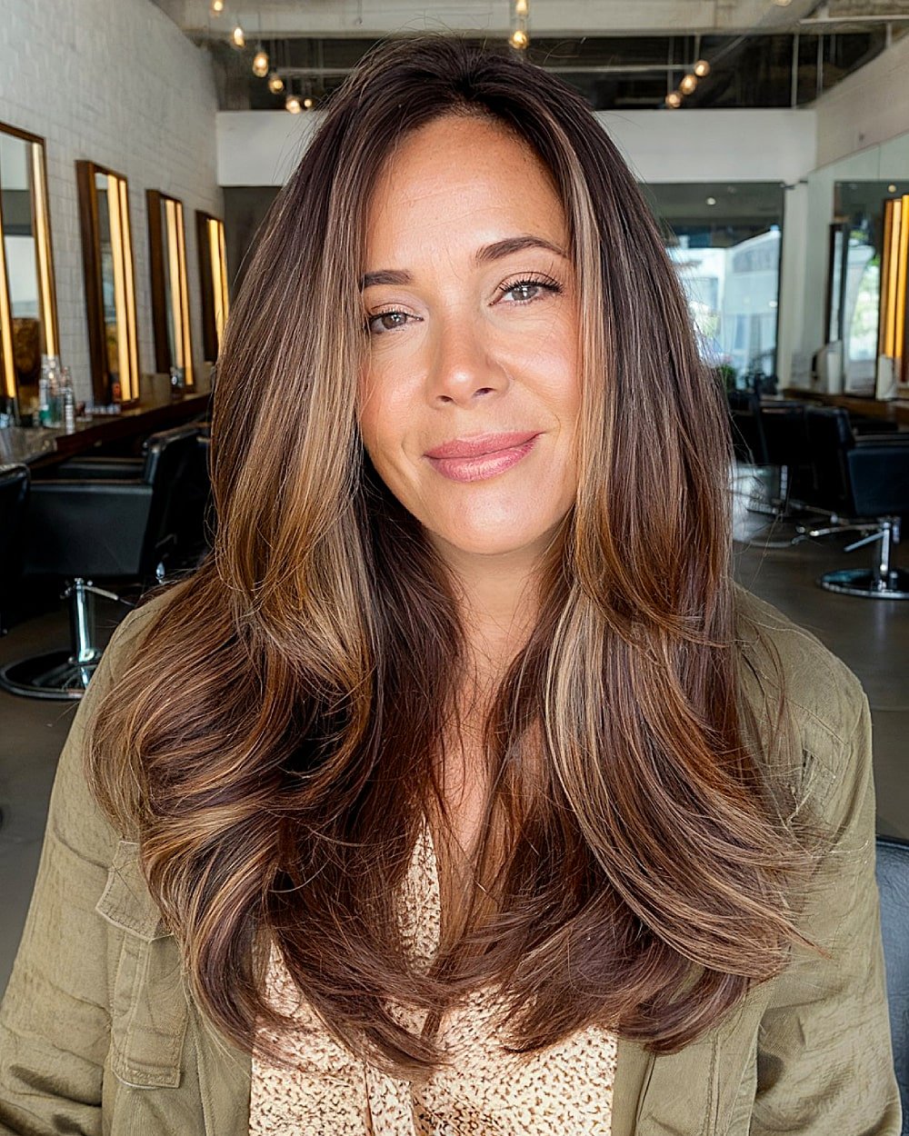 Smooth blowout on long hair with subtle layering and light caramel highlights