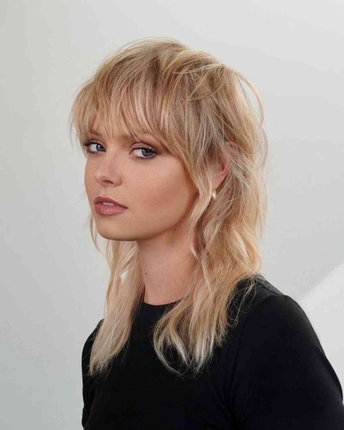 Soft blonde shag haircut with wispy bangs and layered waves on fine to medium hair