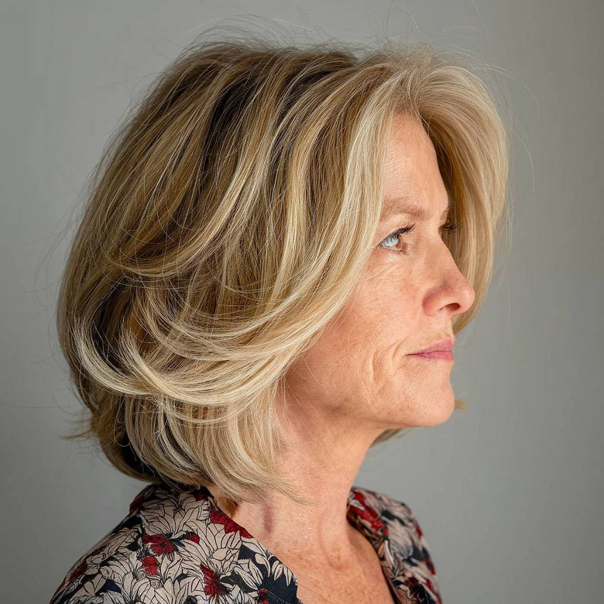 Softly layered angled bob with feathered ends, creating a gentle, airy movement for mature women