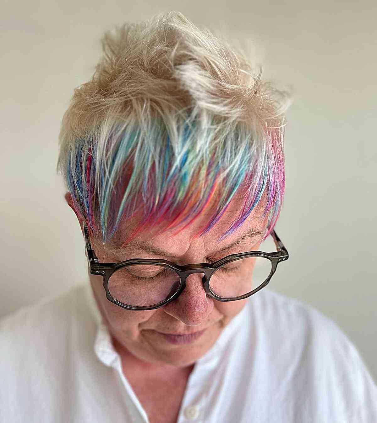 Short Spiky Blonde Pixie with Rainbow Bangs for Older Women Over 60 with Round Glasses