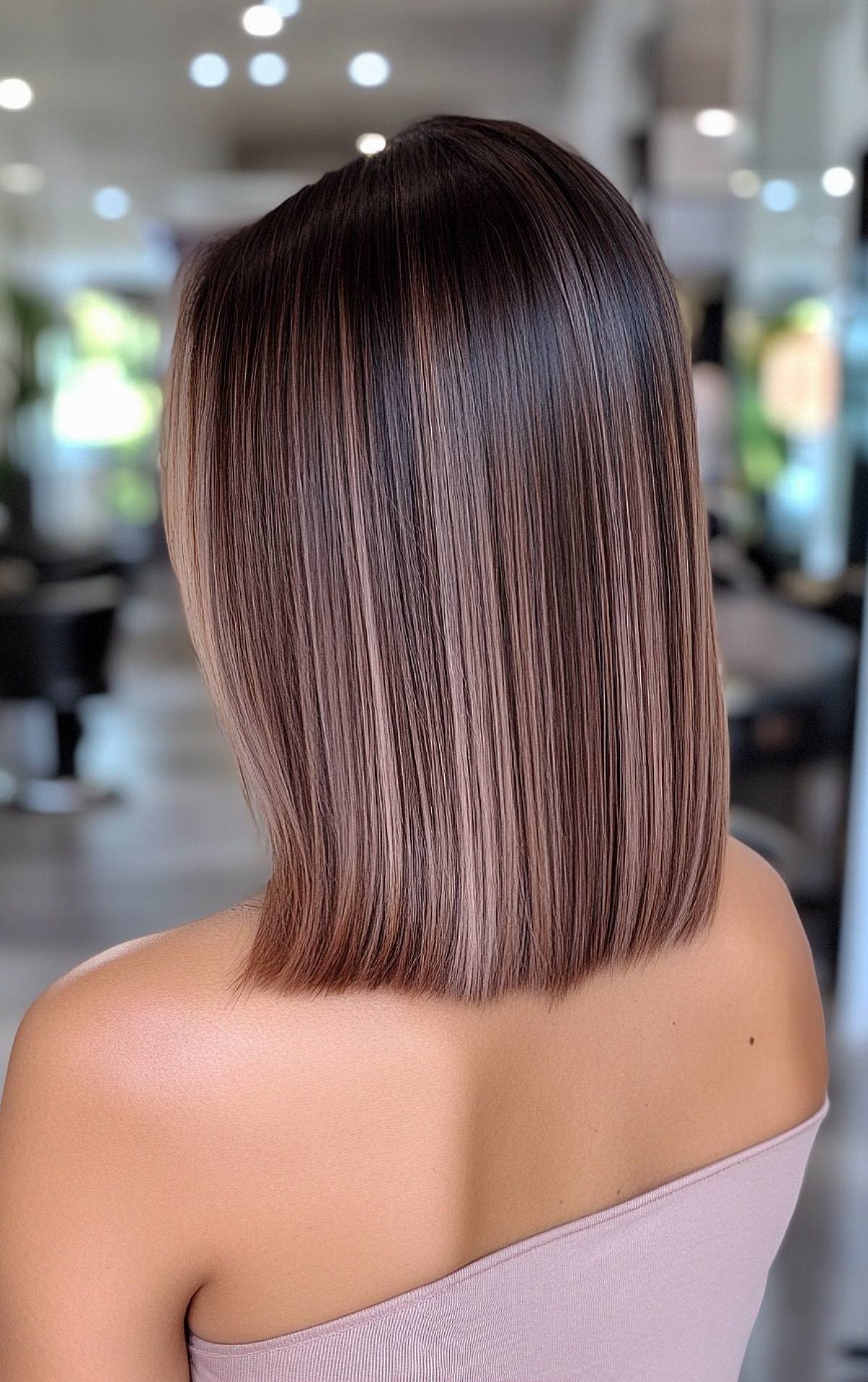 Straight shoulder-length hair with dark roots and ashy brown balayage