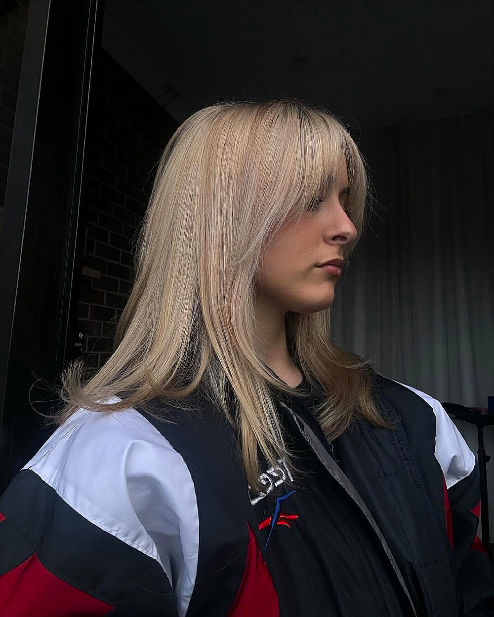 Straight shag cut with wispy curtain bangs on medium-length blonde hair for a soft, layered shape