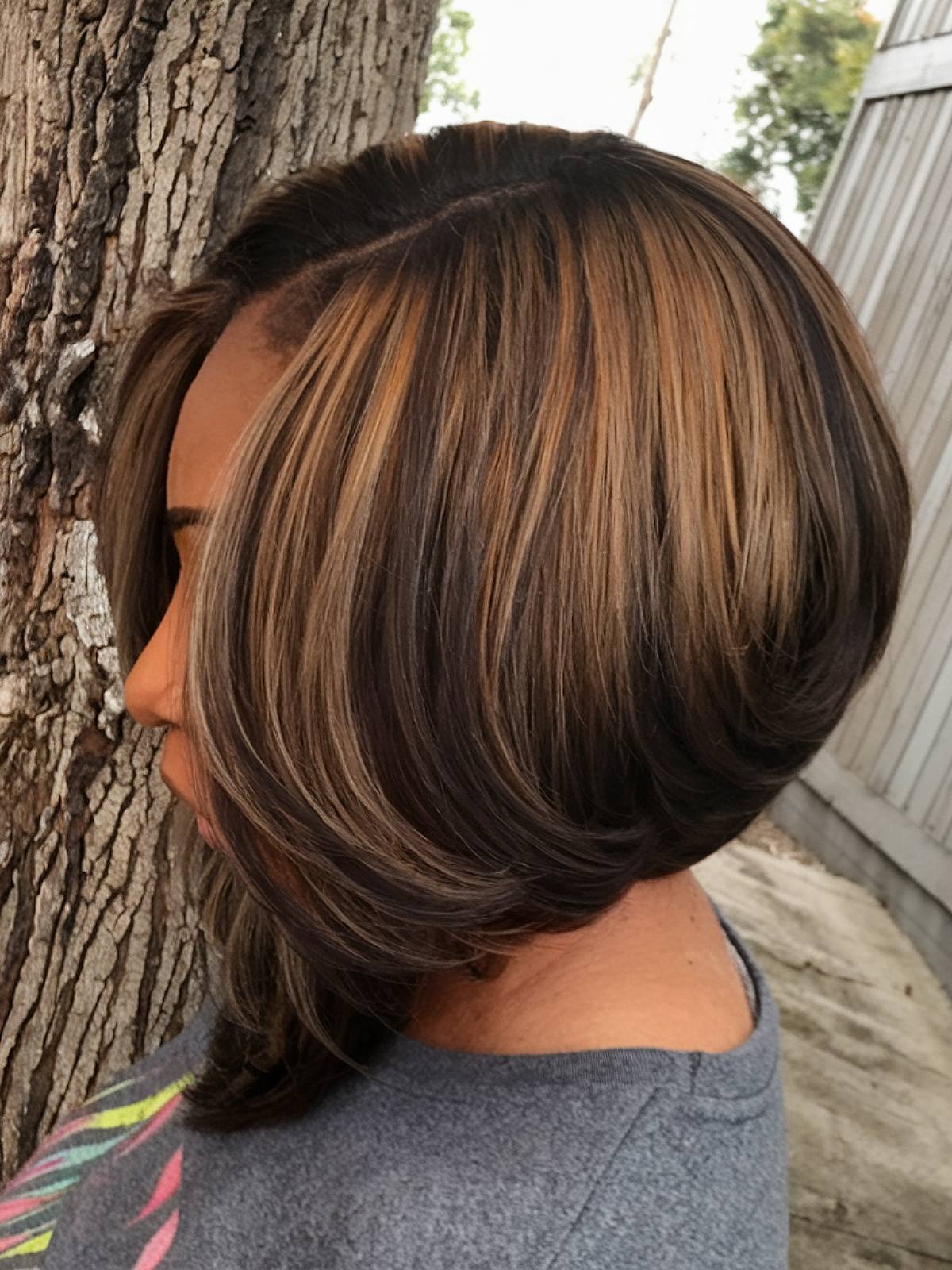 Angled bob haircut for Black women with caramel highlights