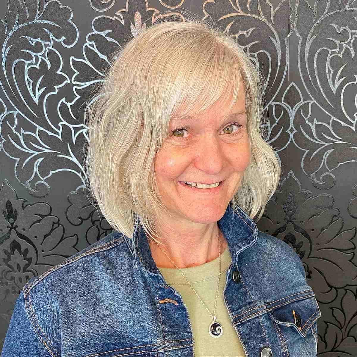 Stylish Blonde Layered Bob with Wispy Bangs for 60-Year-Olds