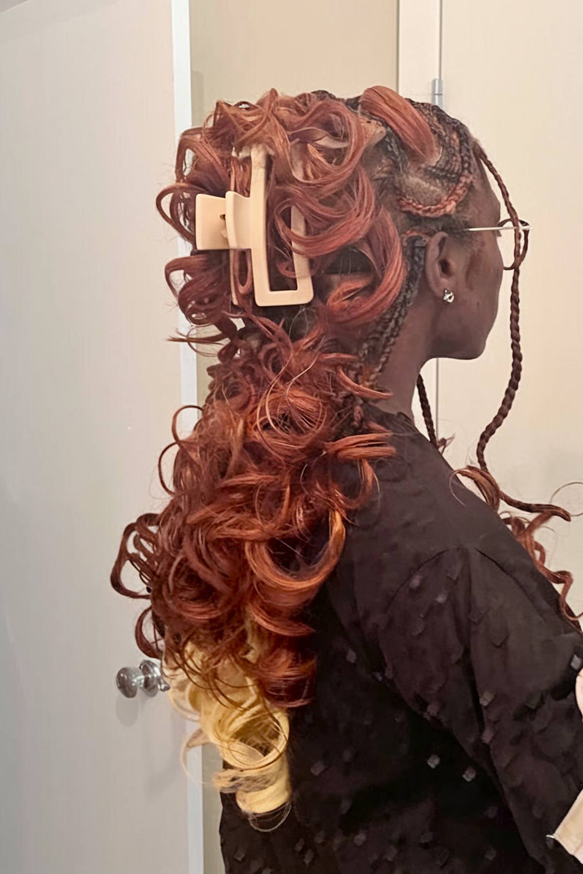 Red French curls with a claw clip and blonde tips