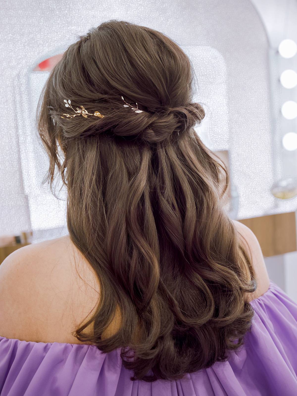 Dark half-up wedding hair with a golden hairpiece