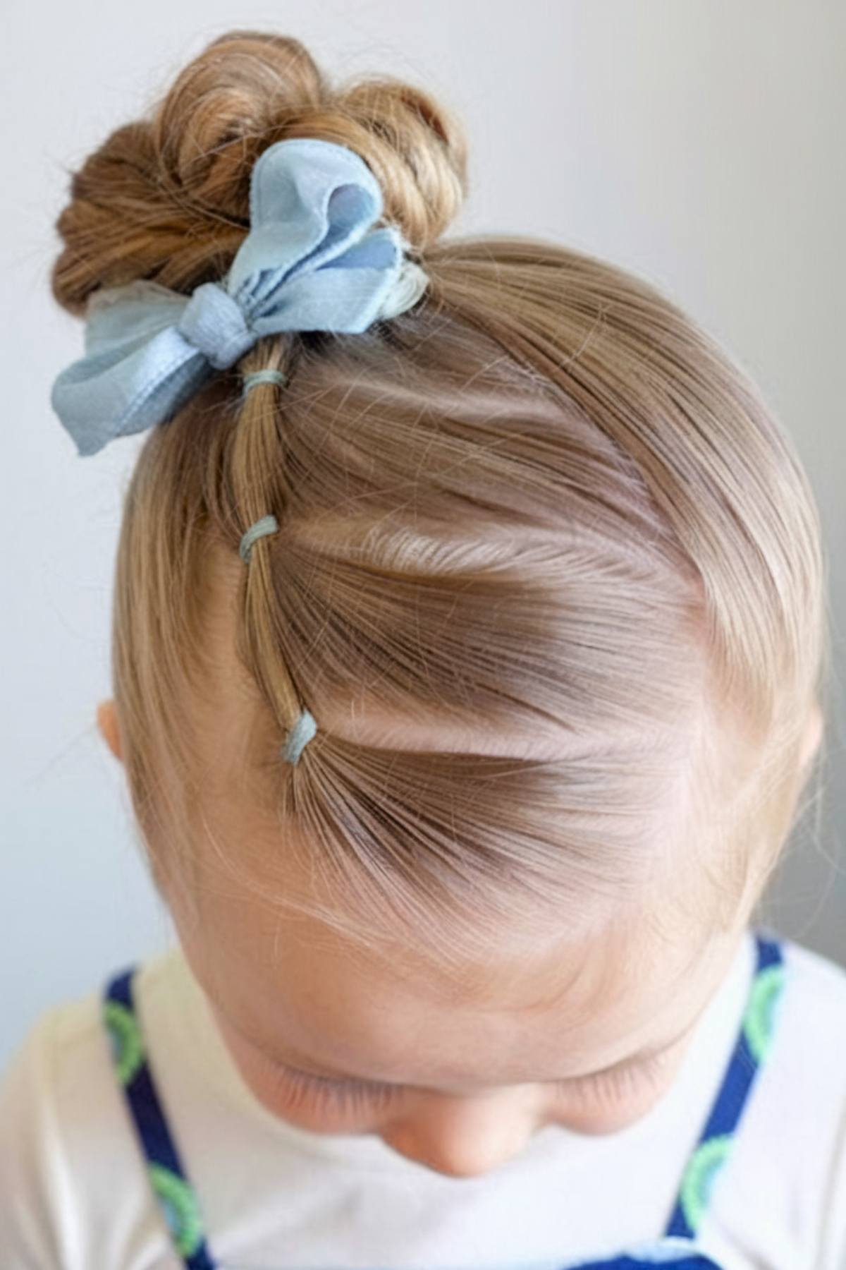 Twisted updo toddler hairstyle with a bow