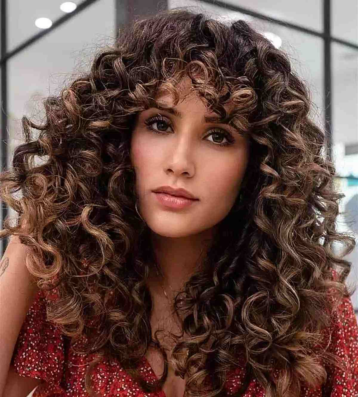 Sun-Kissed Layered Hair with Curly Bangs for Women with Thick Locks and Medium Cut 