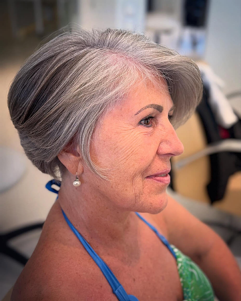 Tapered silver pixie with side volume for women over 60 with short grey hair and natural texture