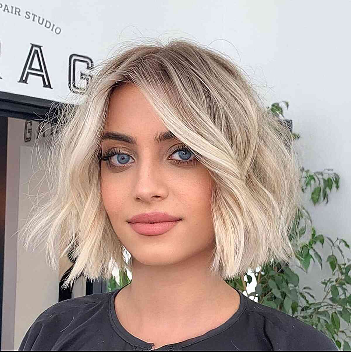 Textured and Blunt Creamy Blonde Bob with a Shadow Root and beach waves at the neck line
