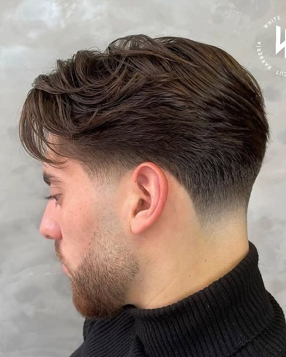 Textured comb over with low taper fade on thick straight hair for a modern men's haircut