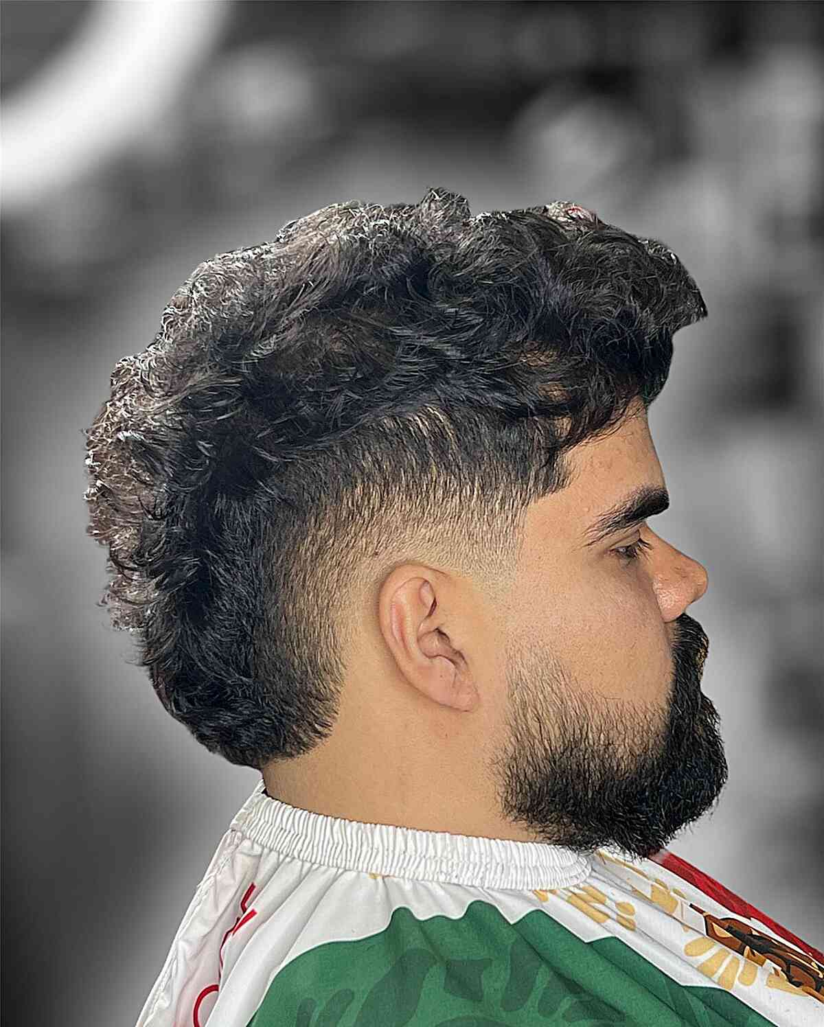 Textured Mohawk with a Low Burst Fade for Men's Wavy Hair