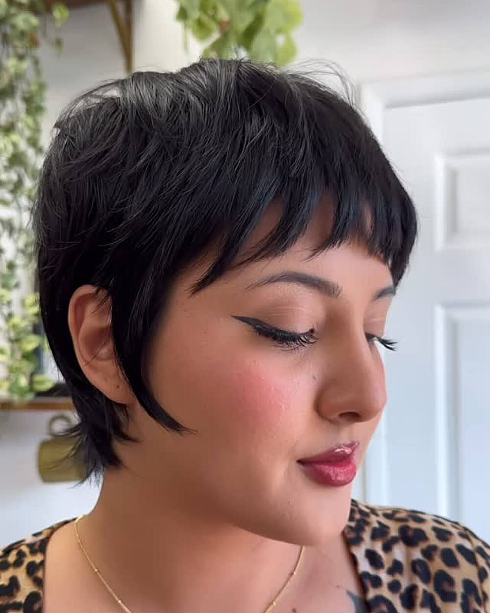 Textured wixie cut with choppy layers and micro bangs on thick dark hair