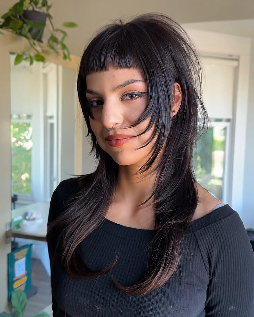 Textured wolf cut with micro bangs on straight, medium-length thick hair styled with choppy layers and feathered ends.