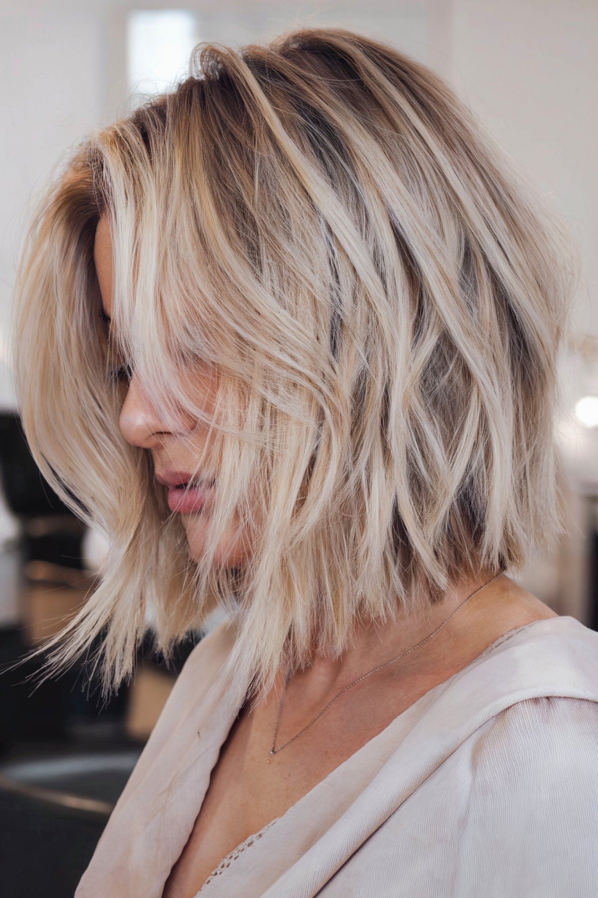 Whisper bob hairstyle with subtle layers and blonde balayage