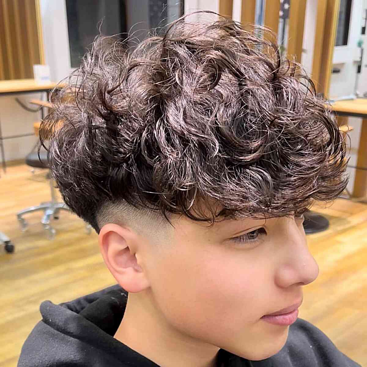 Thick and Messy Curls for Younger Guys with a bald fade and undercut