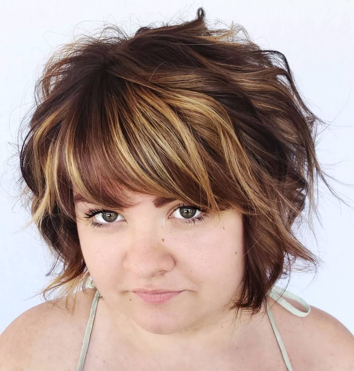Thick bangs on a neck-length bob for round faces