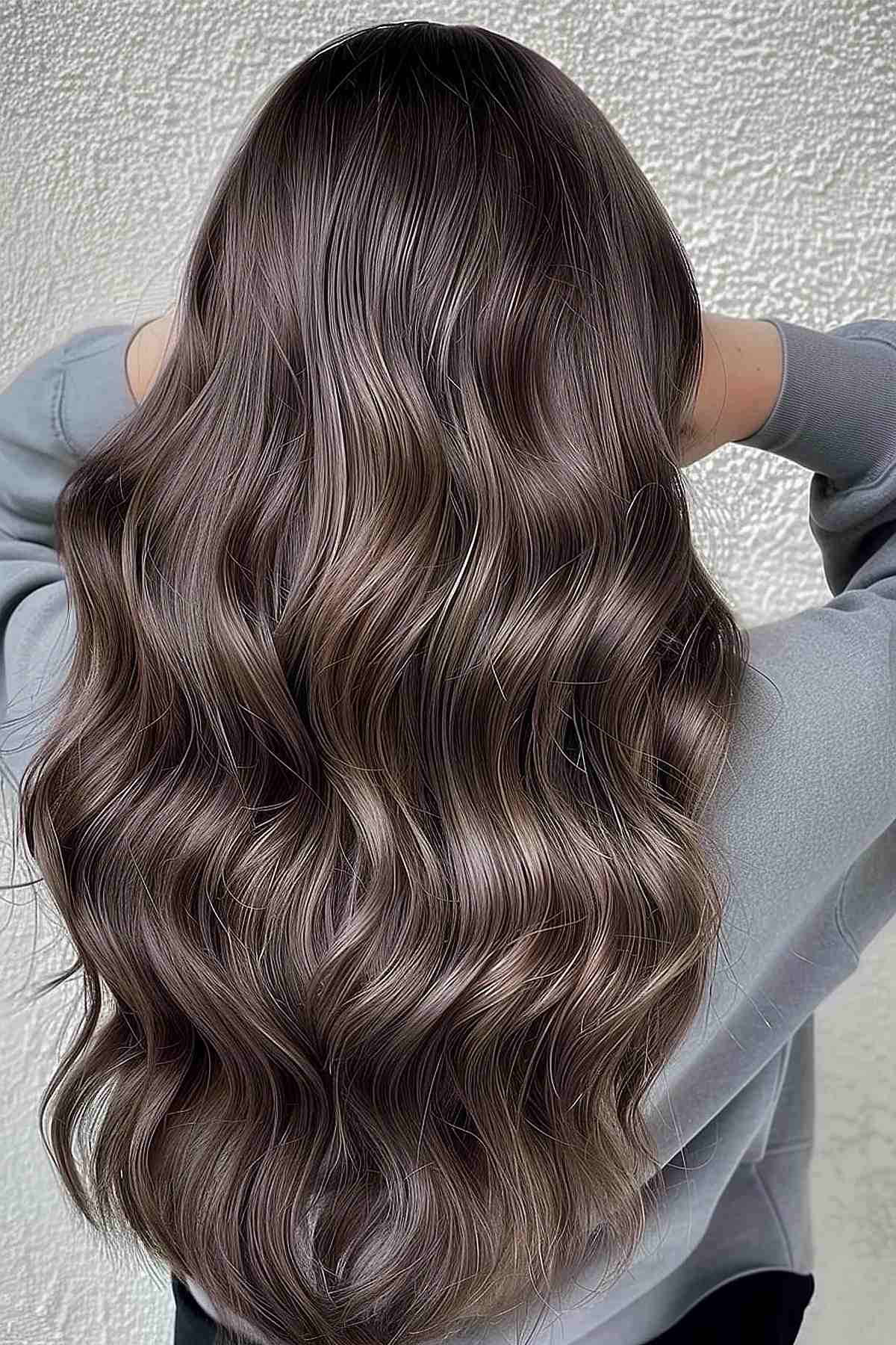 Luxurious long waves in toner-enhanced mushroom brown, reflecting a multi-dimensional sheen and adding volume to the hair.
