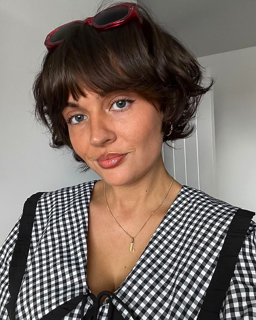 Tousled bob with soft French bangs and layered ends on chin-length brunette hair