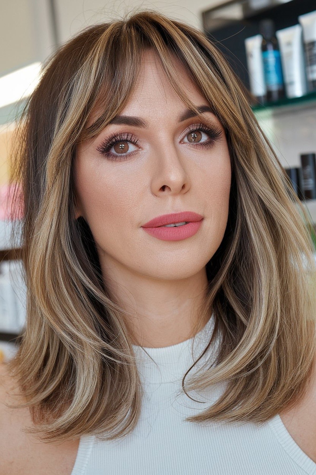 Medium-length haircut with curtain bangs and soft highlights