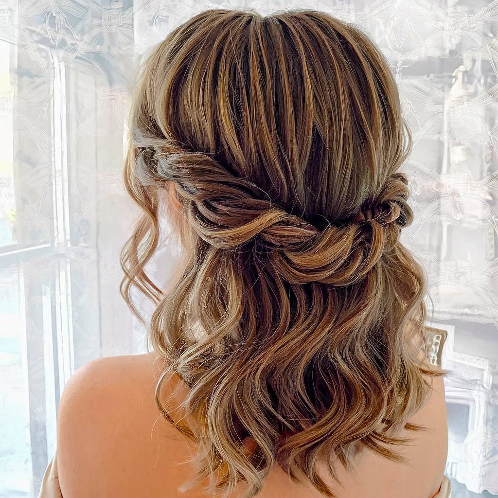 Twisted half up half down prom hairstyle with loose, wavy ends