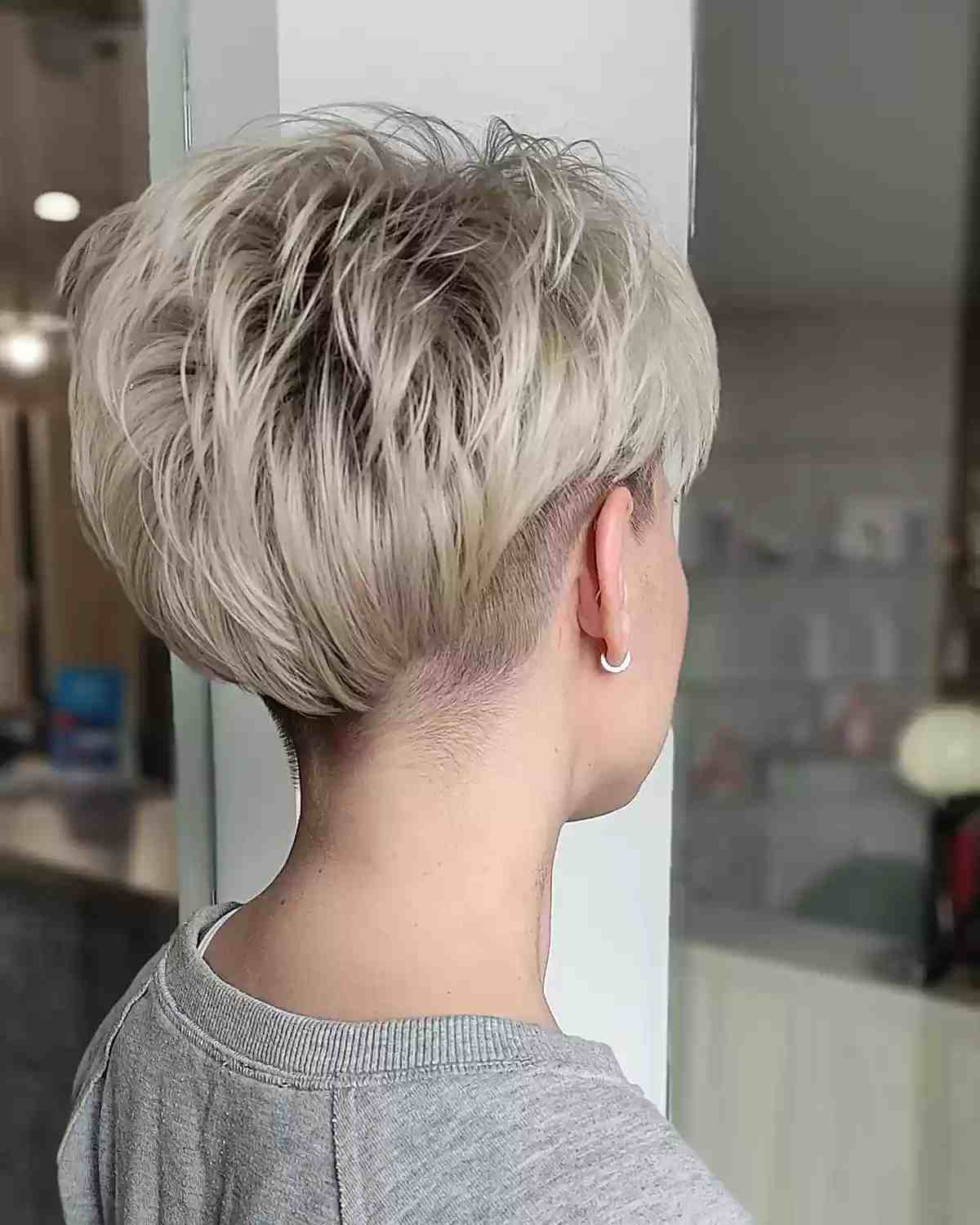 Undercut Pixie Cut with Shaved Nape on women with short blonde hair
