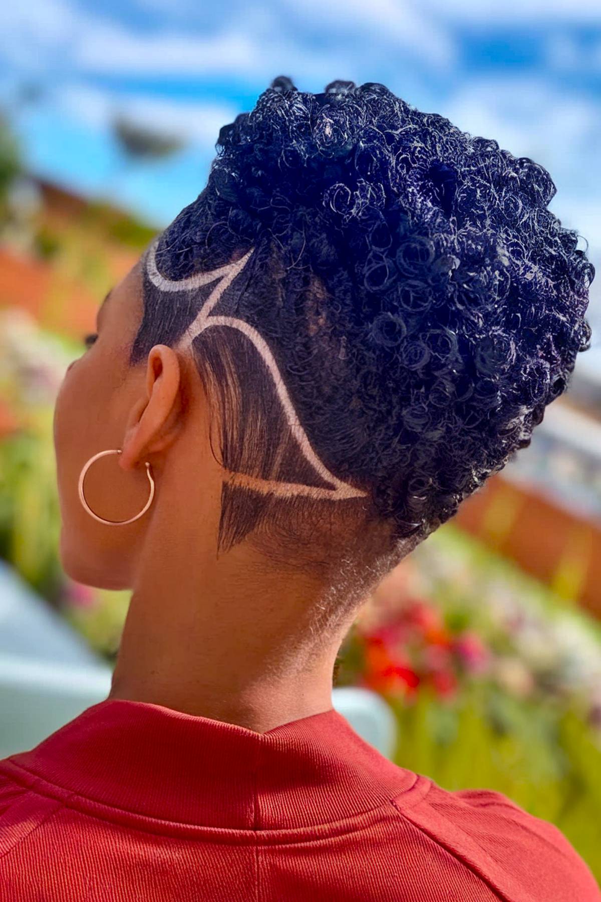 Undercut with shaved designs and natural curls