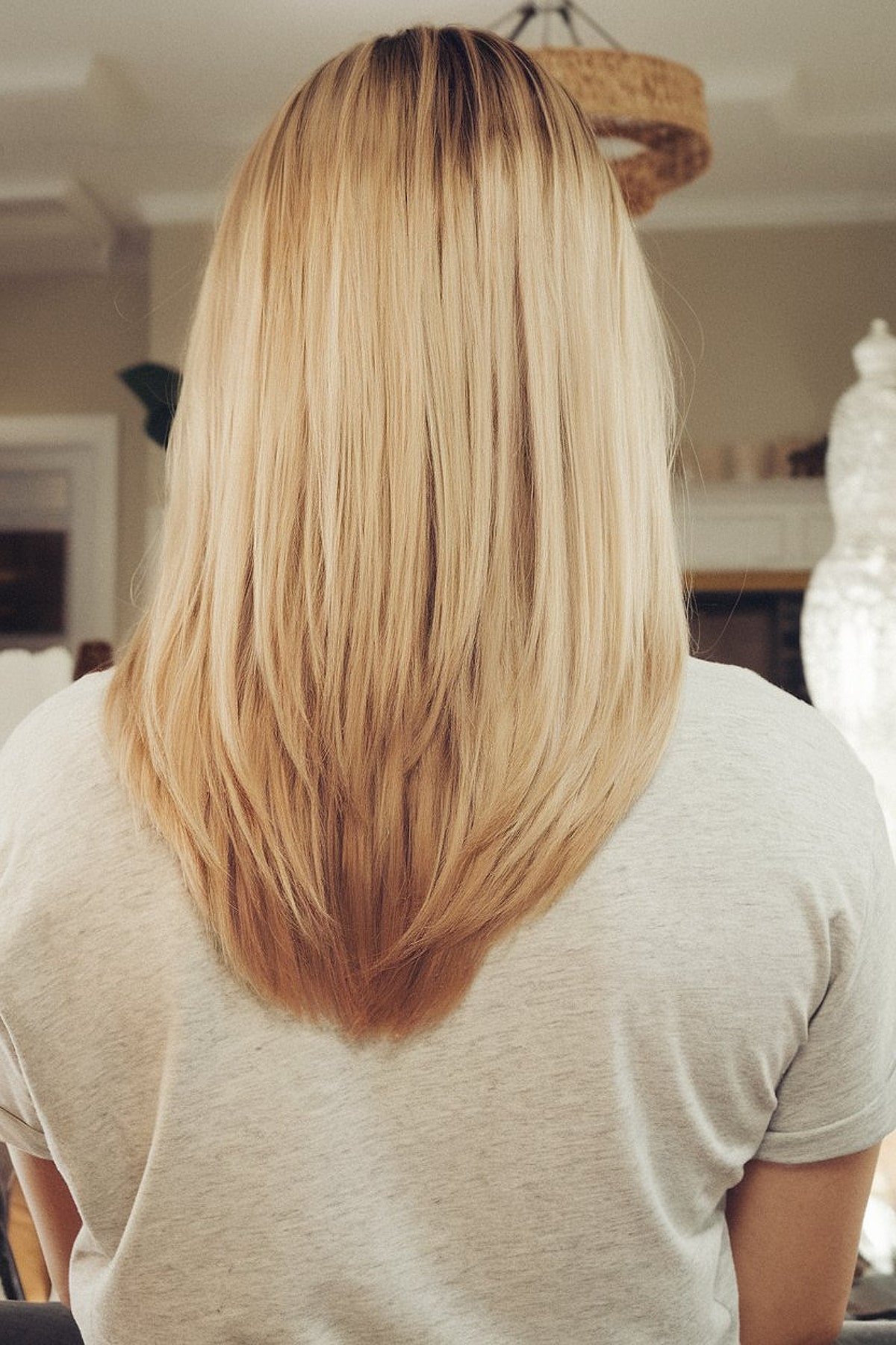 V-cut layers on mid-length blonde hair for added movement and shape