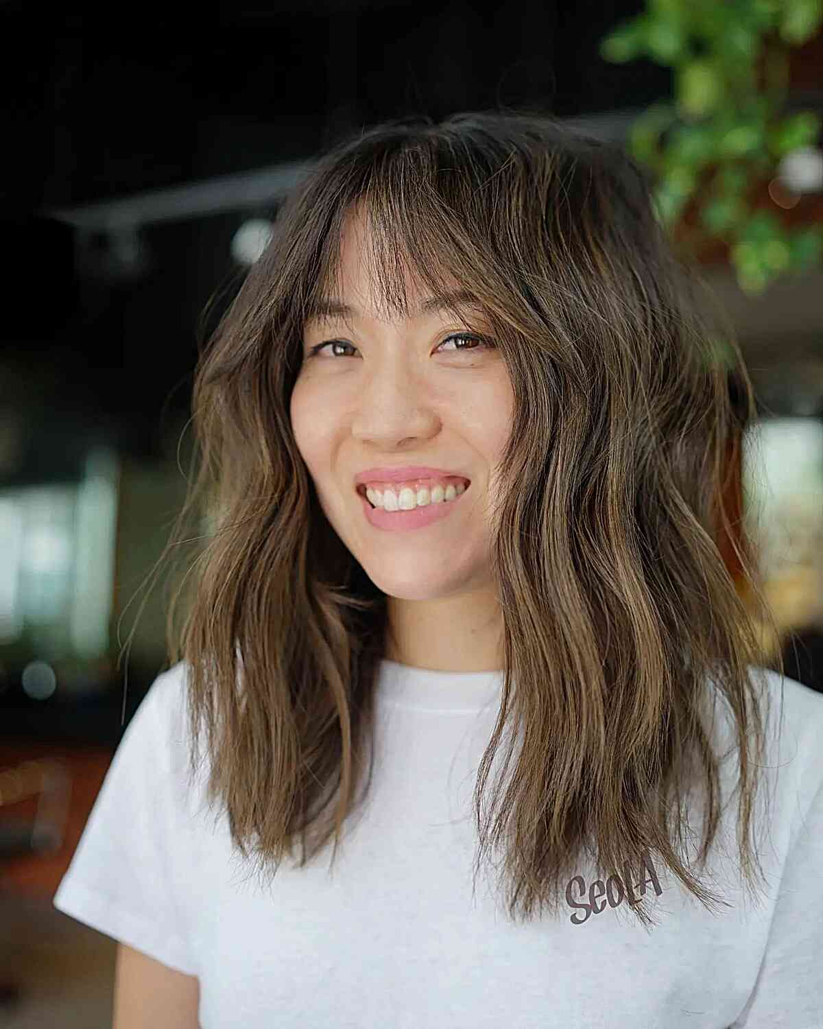Versatile Brunette Mid-Length Chop with wispy bangs and textured layers