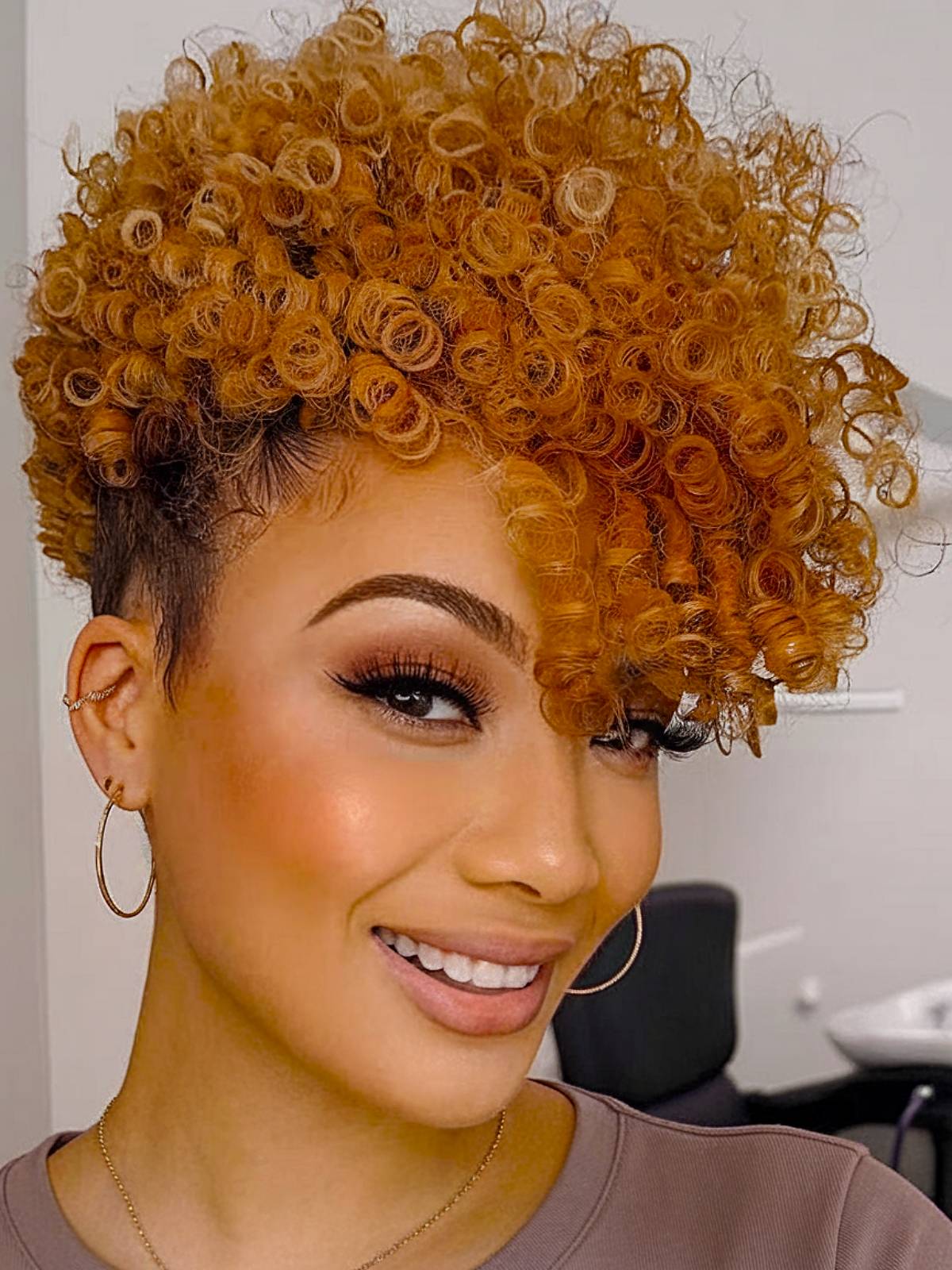 Copper-toned curls with shaved undercut for natural hair