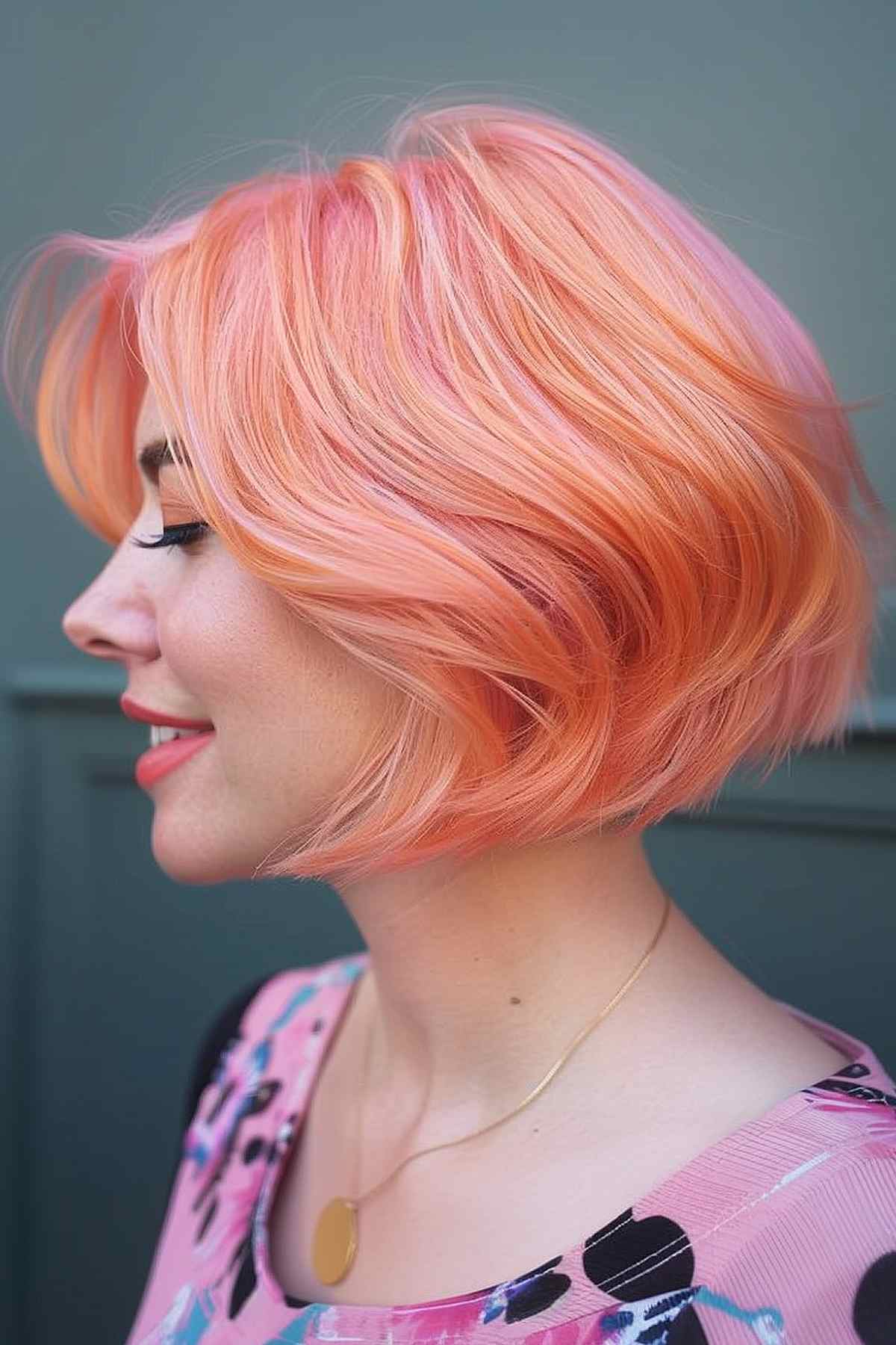 Woman with a stylish above-the-shoulder bob in vibrant peach color, showcasing a fresh, youthful, and low-maintenance hairstyle.