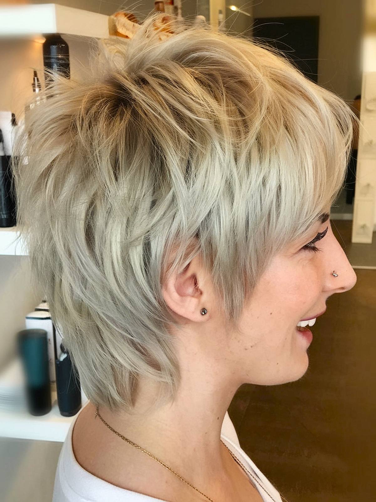 Edgy queer-style short layered haircut with messy platinum blonde layers