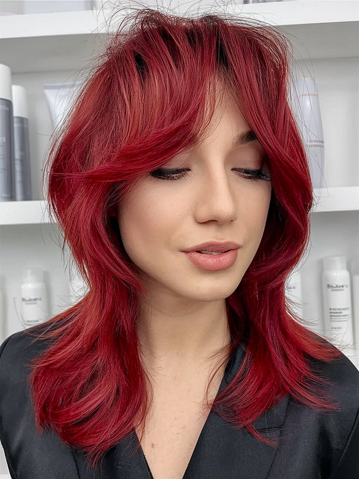 Red medium length layered haircut with vibrant color