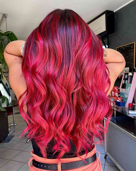 A Vivid Red Balayage with Dark Roots for women with long wavy hair