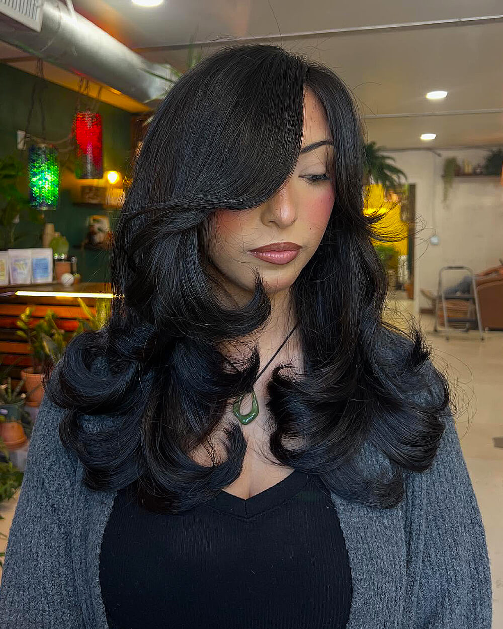 Butterfly haircut with face-framing layers on long, thick hair styled with voluminous blowout