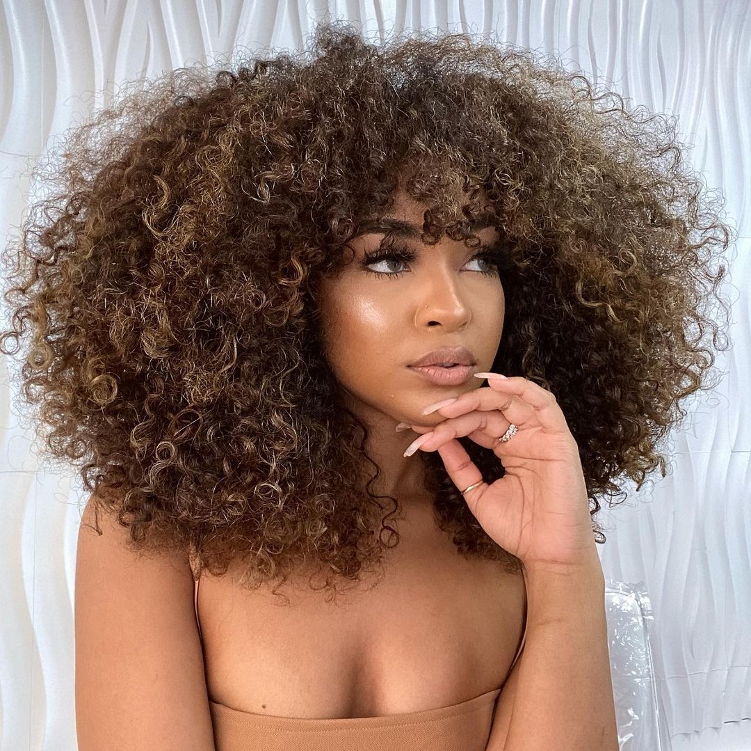 voluminous curly hair with bangs for black women