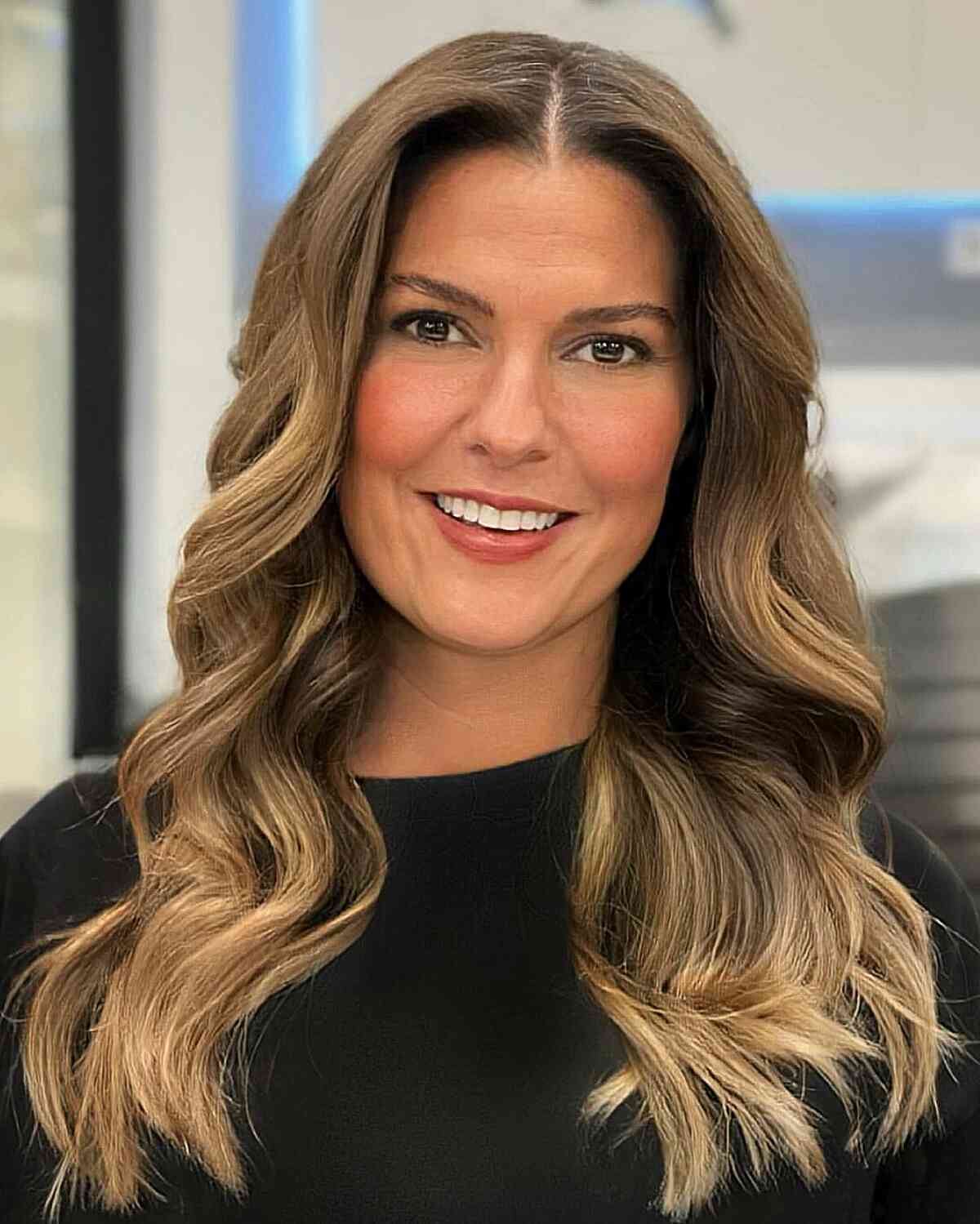 Wavy Blonde Balayage with a Center Part on Long Hair for 40-Year-Olds