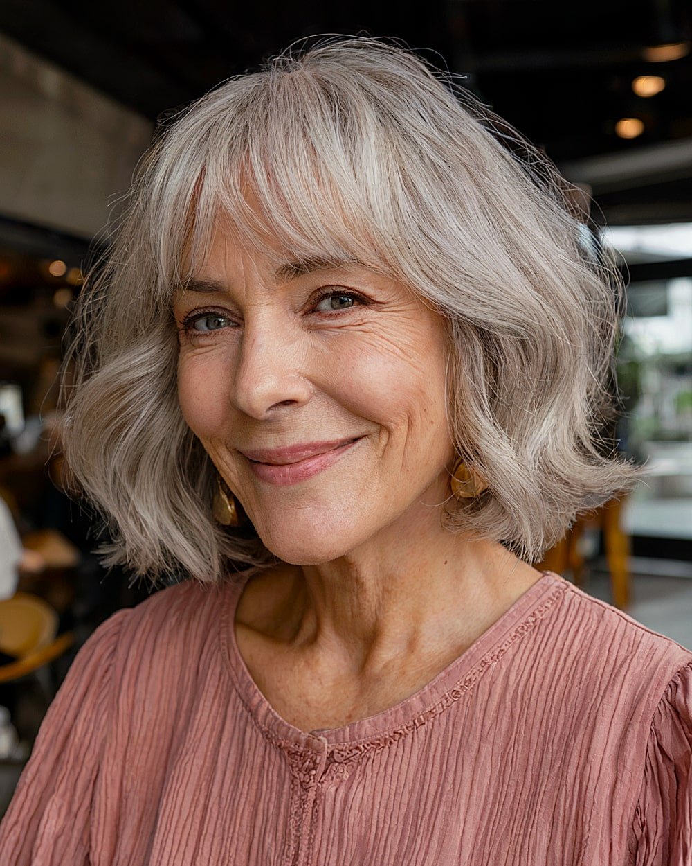 Grey wavy bob with curtain bangs for women over 60, textured layers and movement