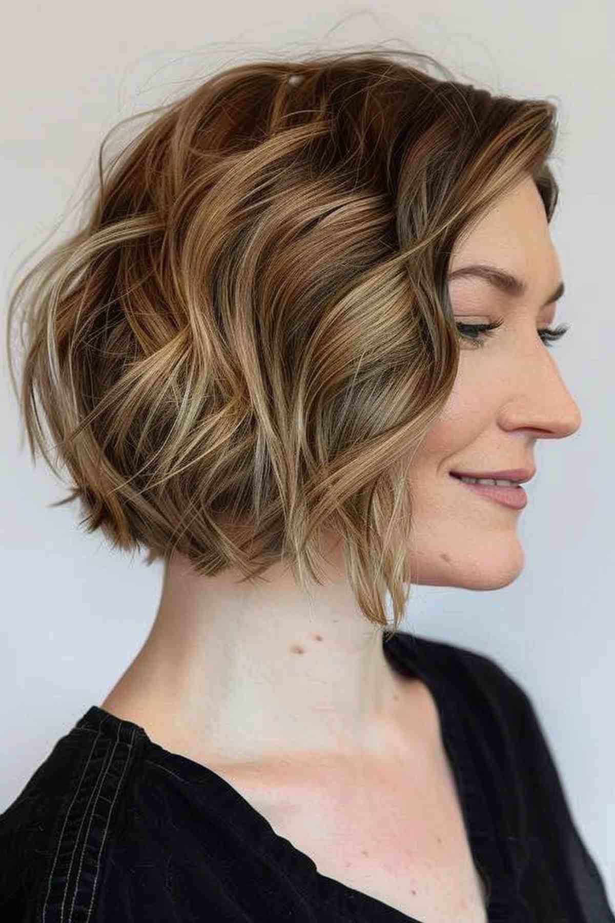 A wavy A-line bob cut with tousled waves and face-framing highlights.