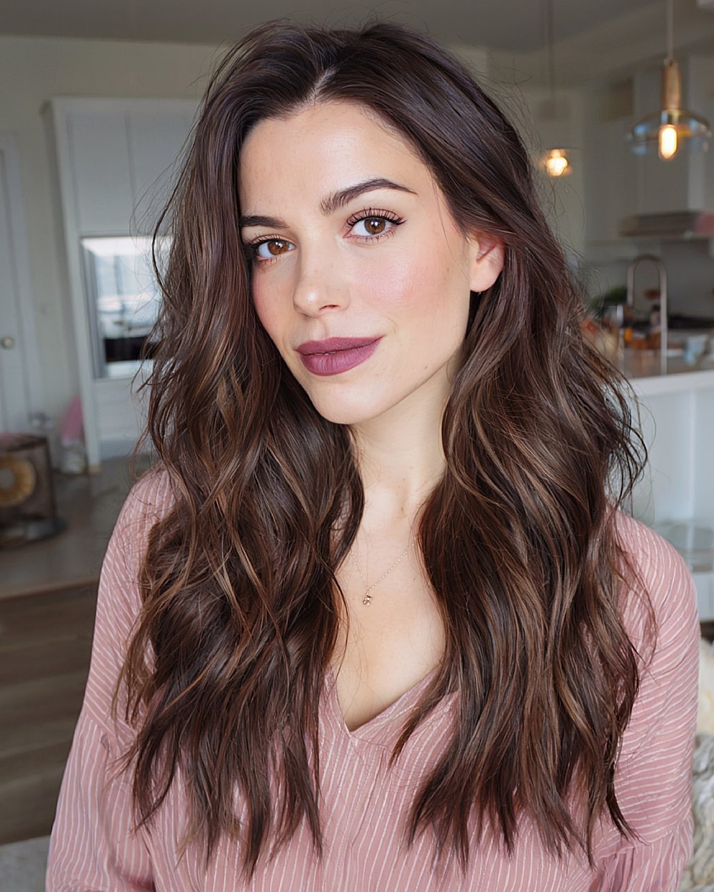 Long brunette wavy hairstyle with blended layers and draped side part