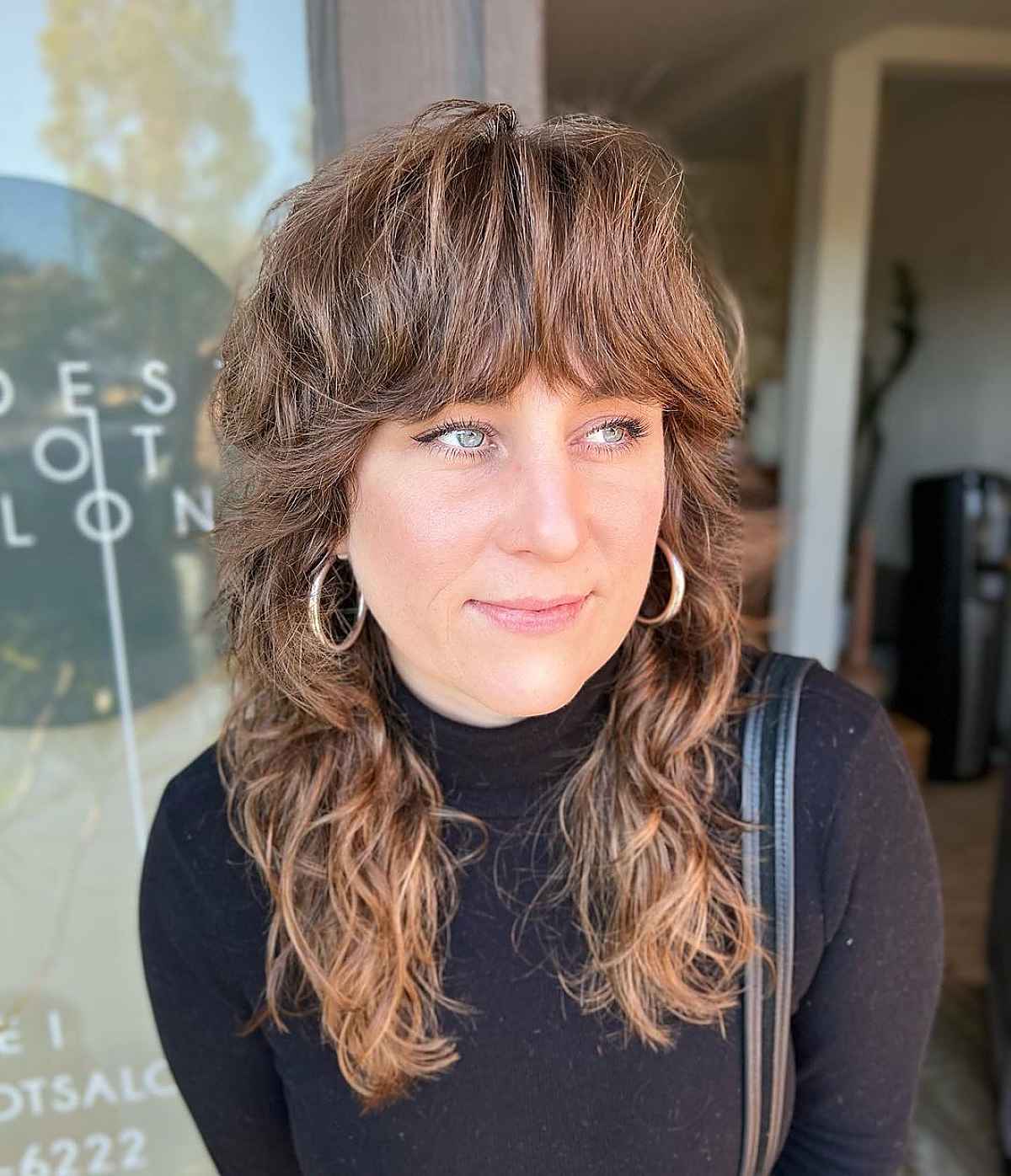 Wavy Shaggy Hairstyle with Brow-Grazing Bangs