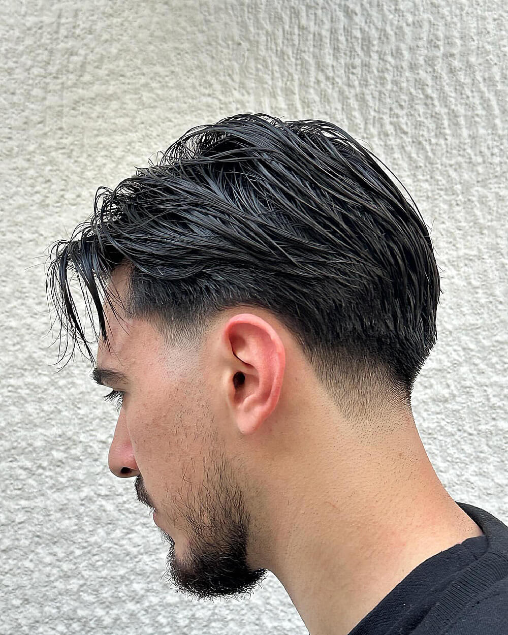 Wet look flow hairstyle paired with clean low taper fade for thick straight hair