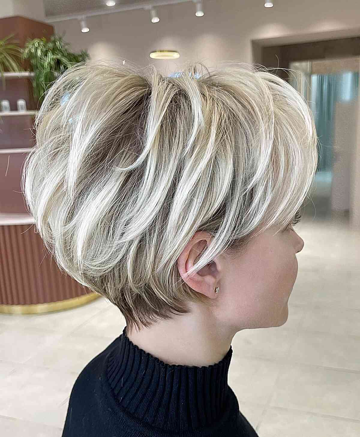 White Blonde Layered Pixie Bob with dark roots and a tapered nape