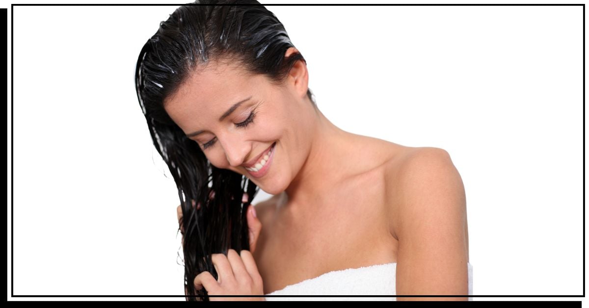Woman applying moisturizer on her hair