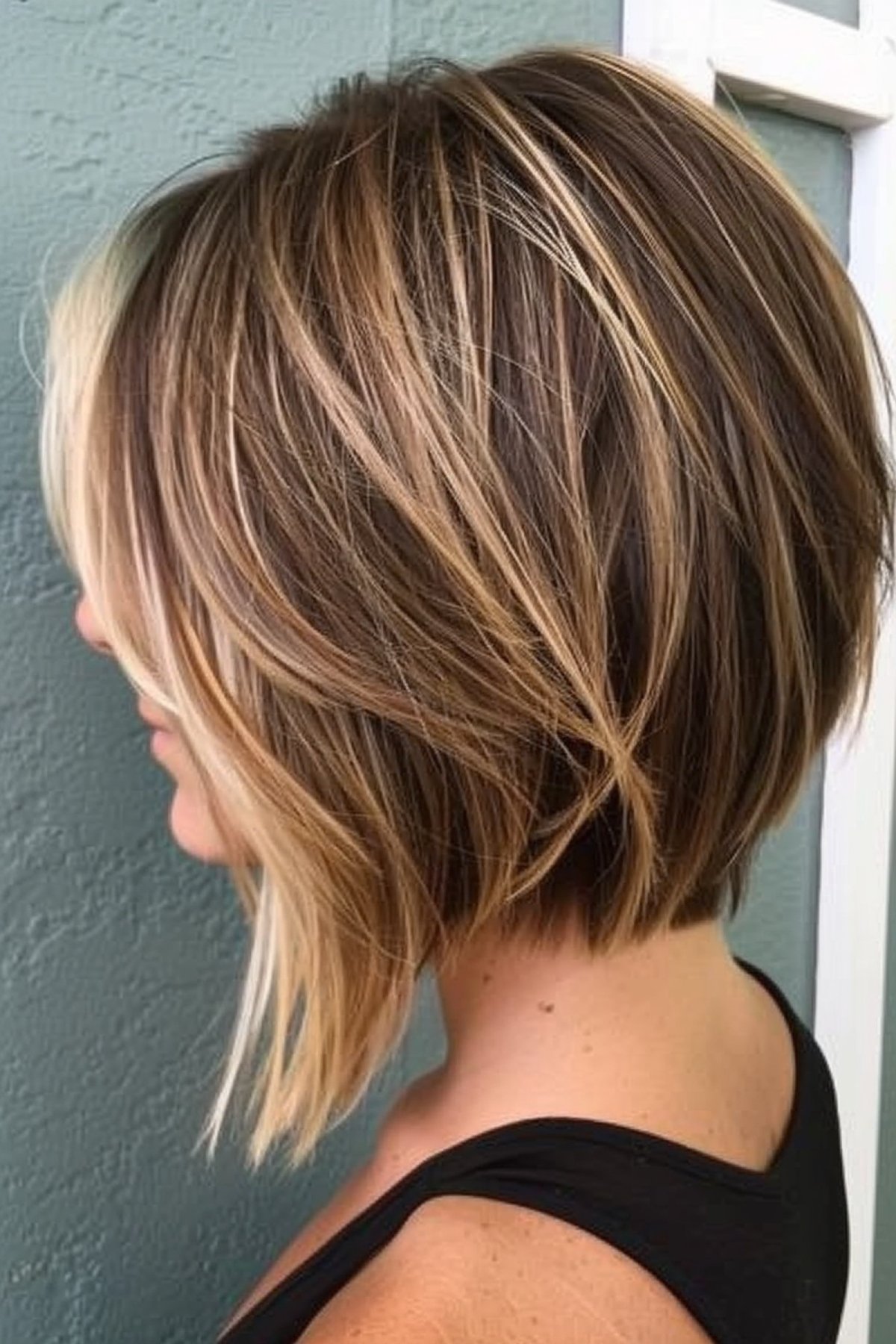 Woman with trendy stacked bob in blonde with dark roots